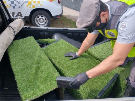 Durante abordagem a veículo, polícia apreende 132 tabletes de cocaína escondidos em caixas revestidas com grama sintética