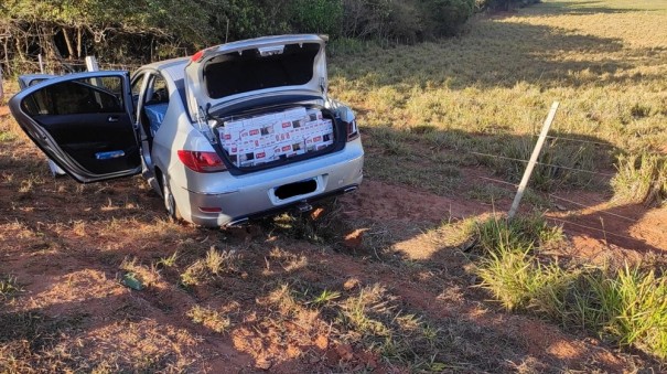 Motorista foge em alta velocidade com 12,5 mil ma�os de cigarros contrabandeados e bate carro em cerca �s margens de rodovia