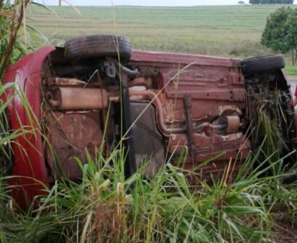Carro ocupado por tr�s pessoas capota e vai parar na vegeta��o 